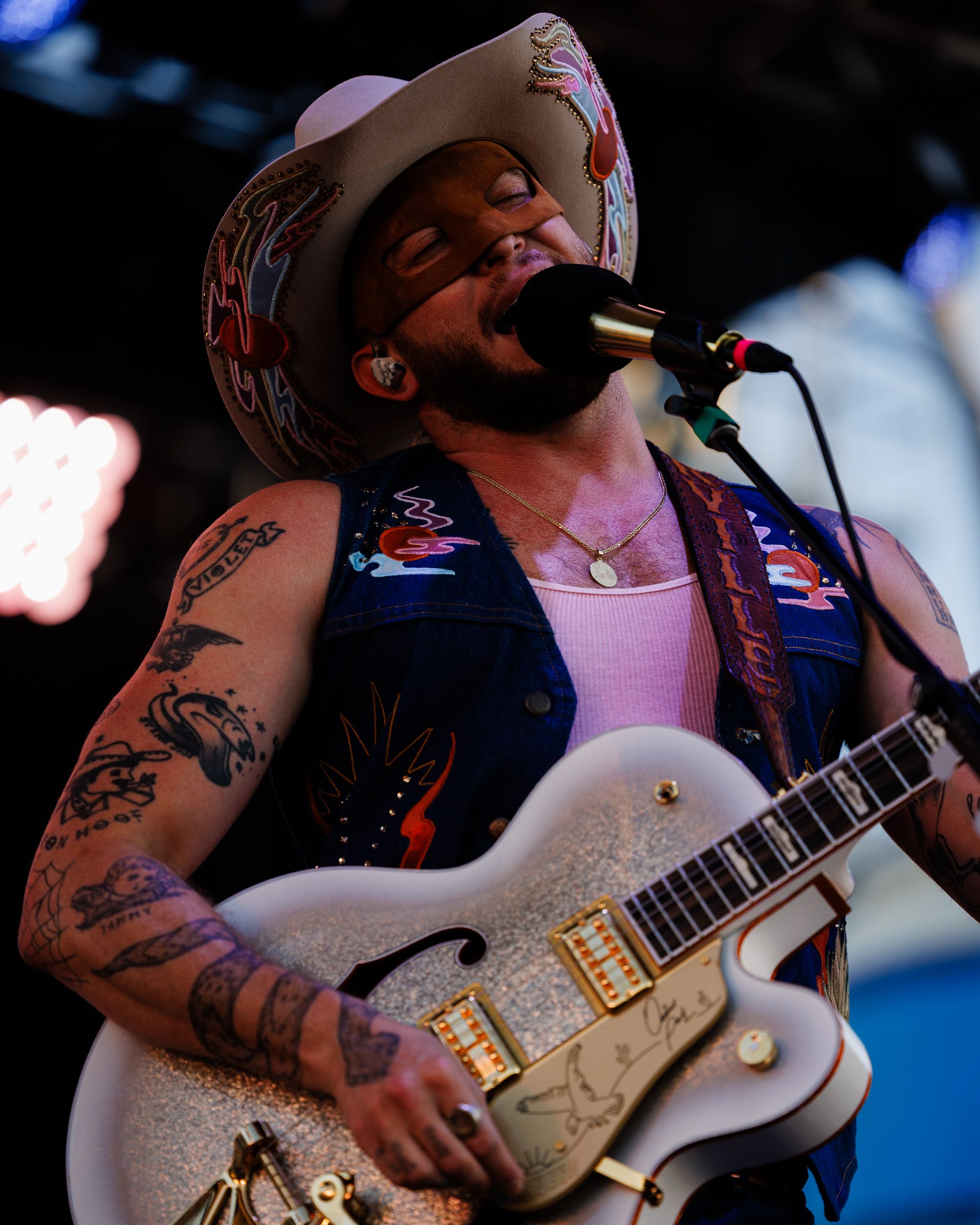 Close detail of a guitarist mid-song on stage