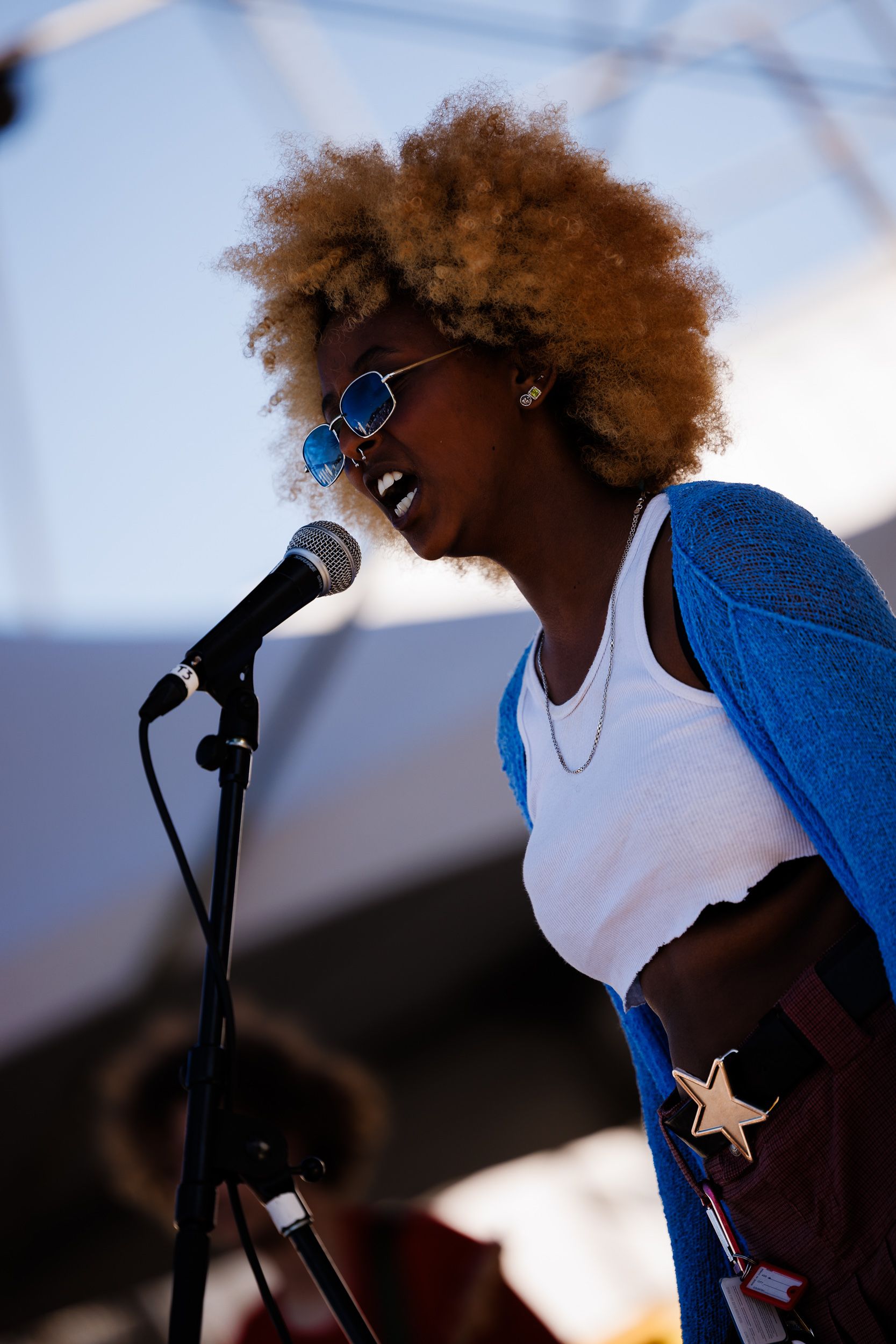 Singer in denim at the microphone in bright daylight
