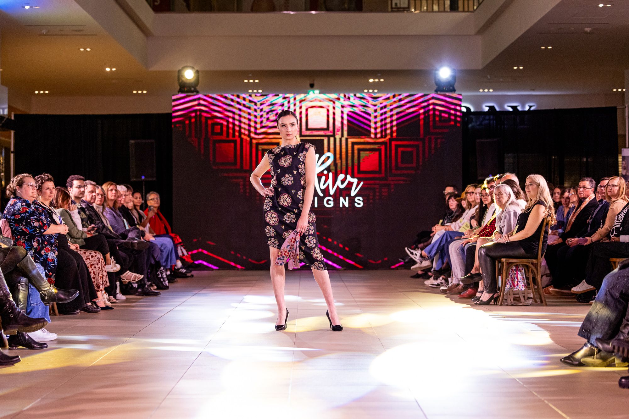 Fashion show moment captured under stage lighting