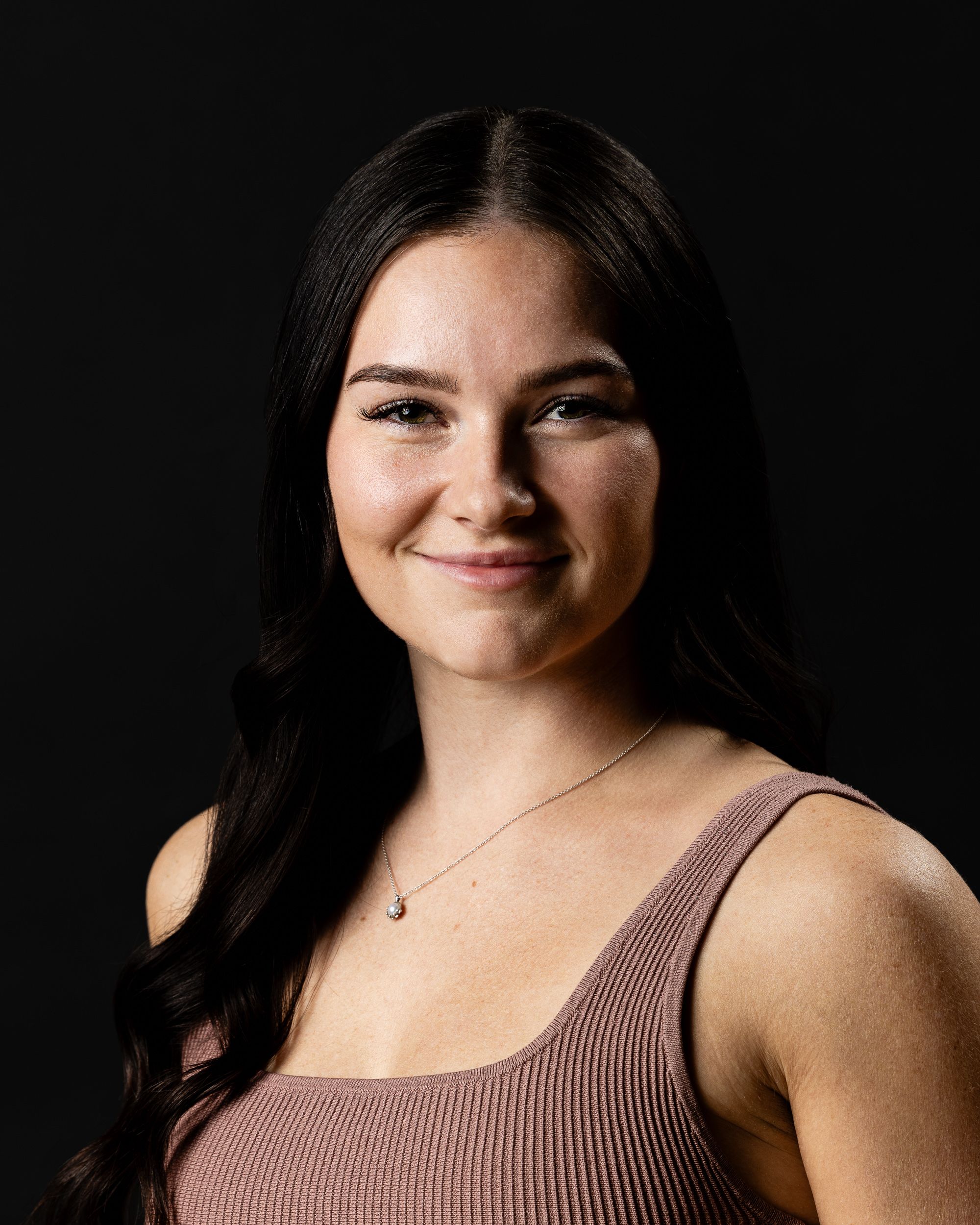 Dark-background professional portrait of a young woman