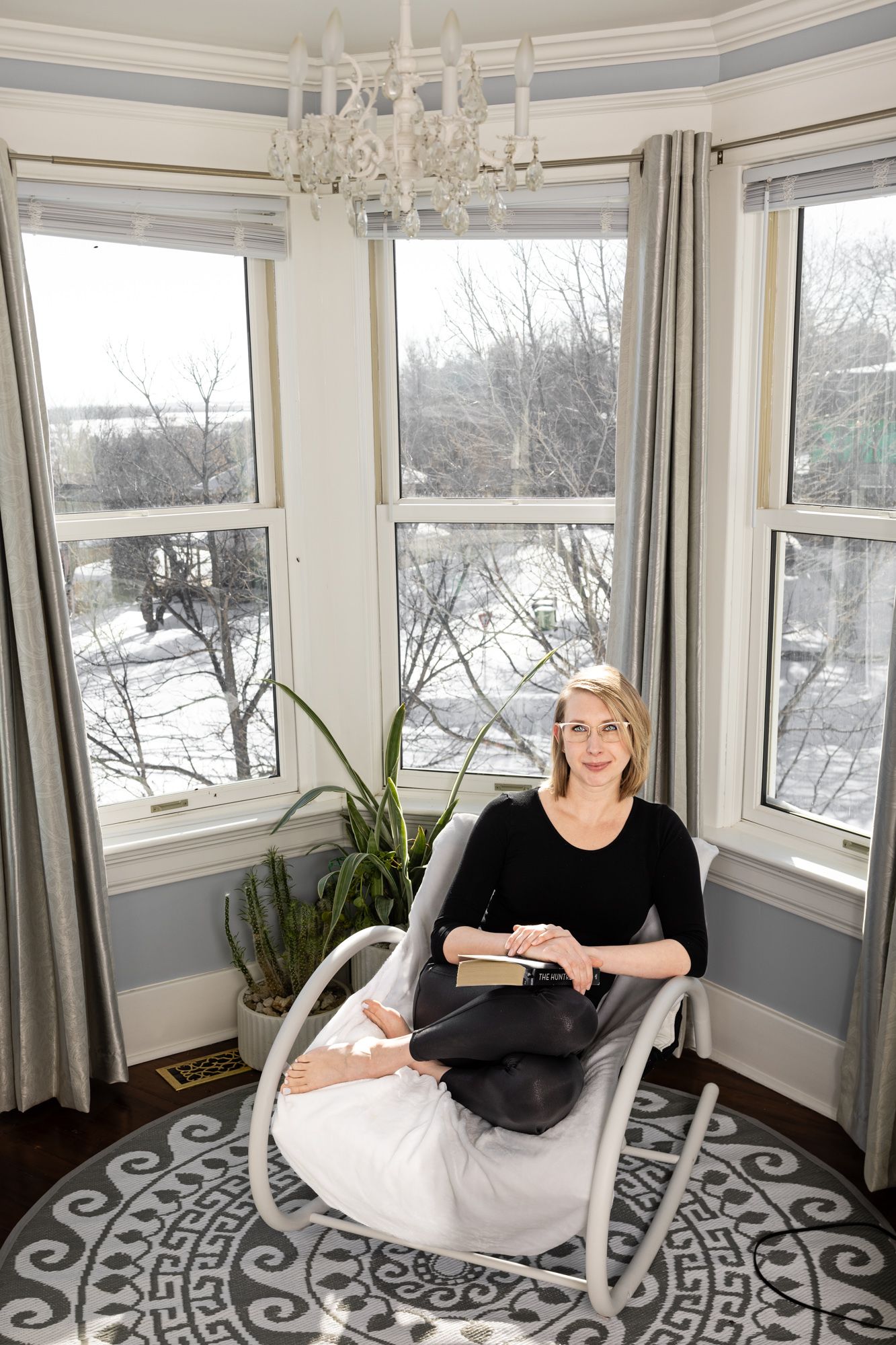 Author photographed at a bright window with a winter view