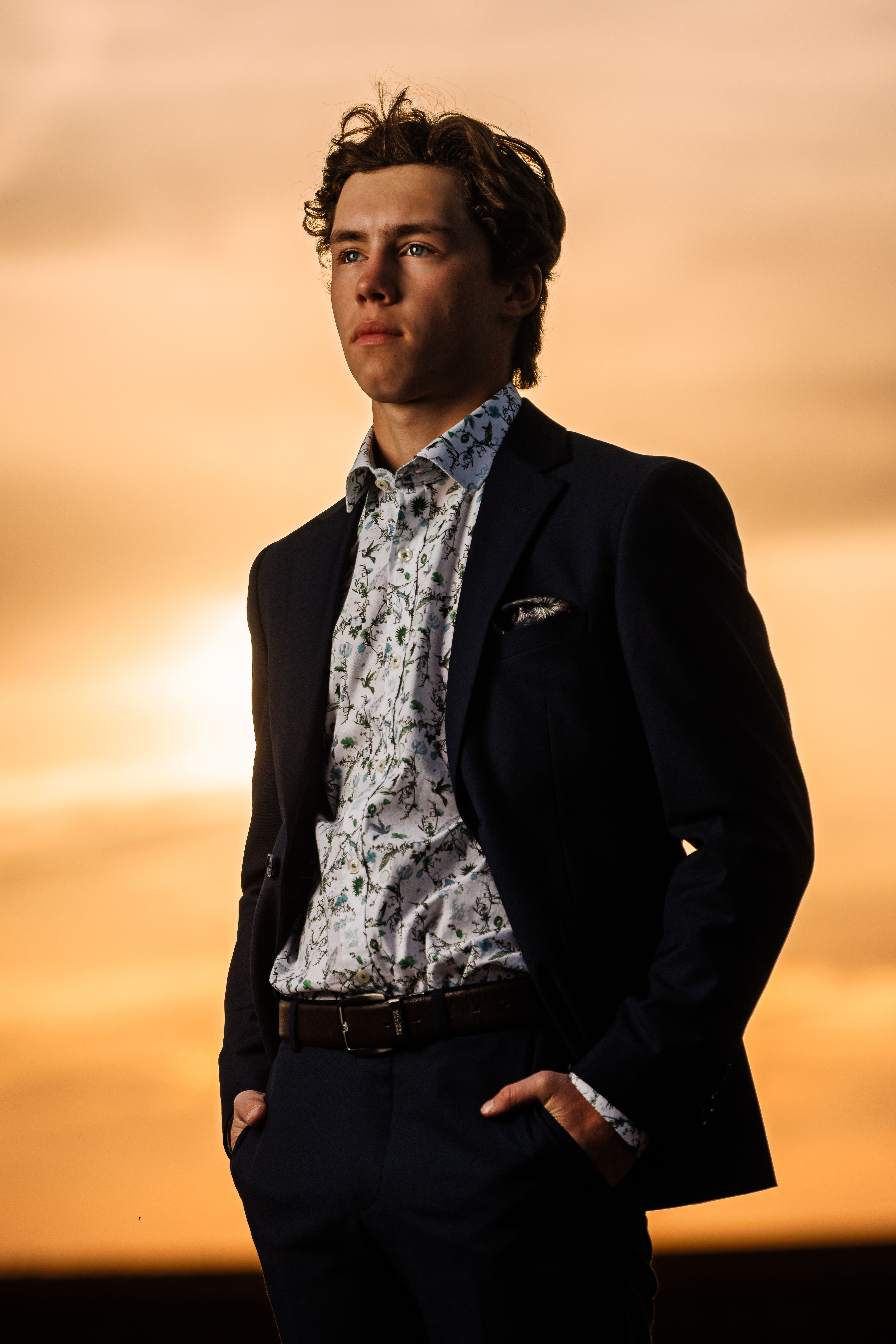 Grad in a suit backlit by golden prairie light