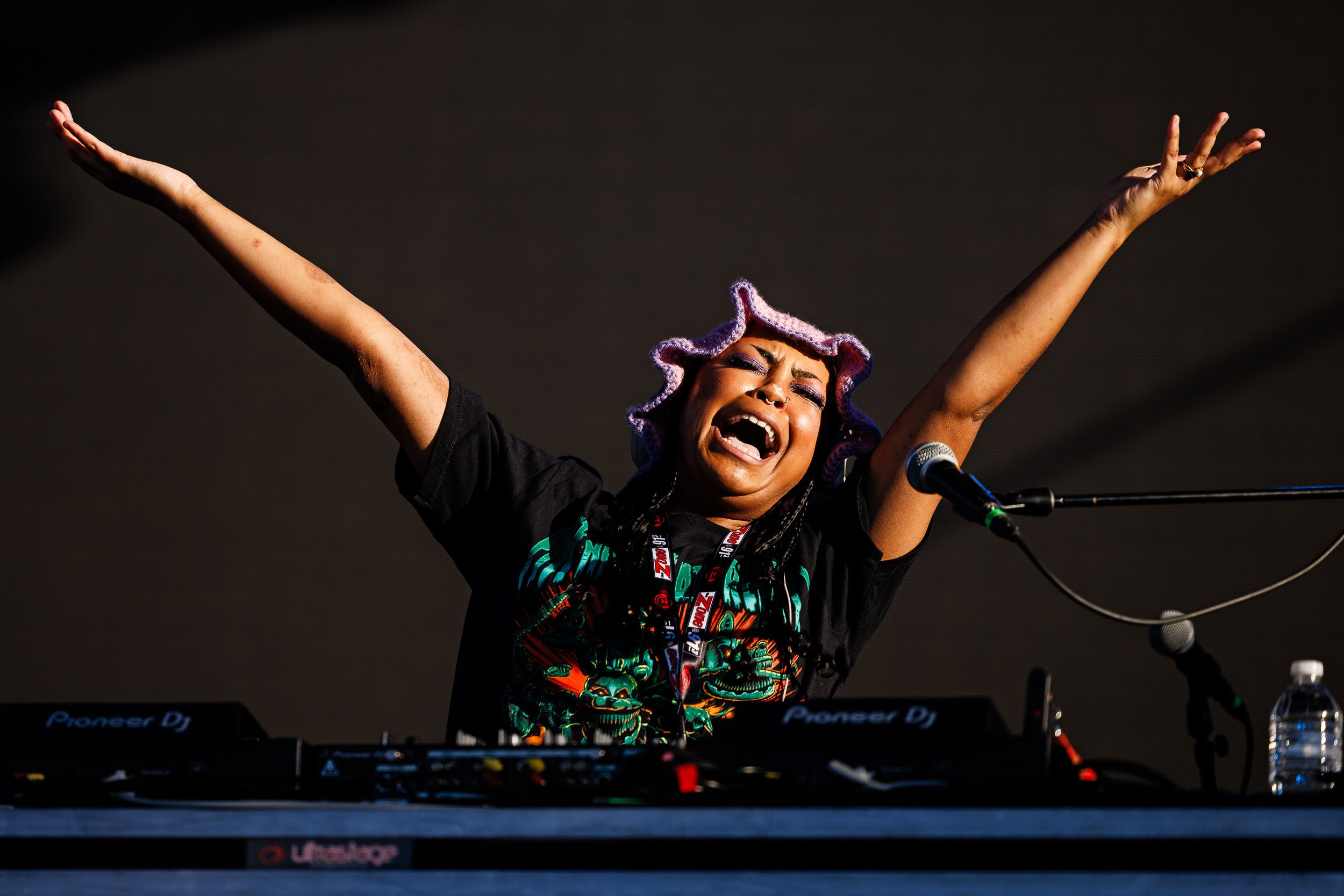 Flyana Boss performing with arms spread wide on a festival stage