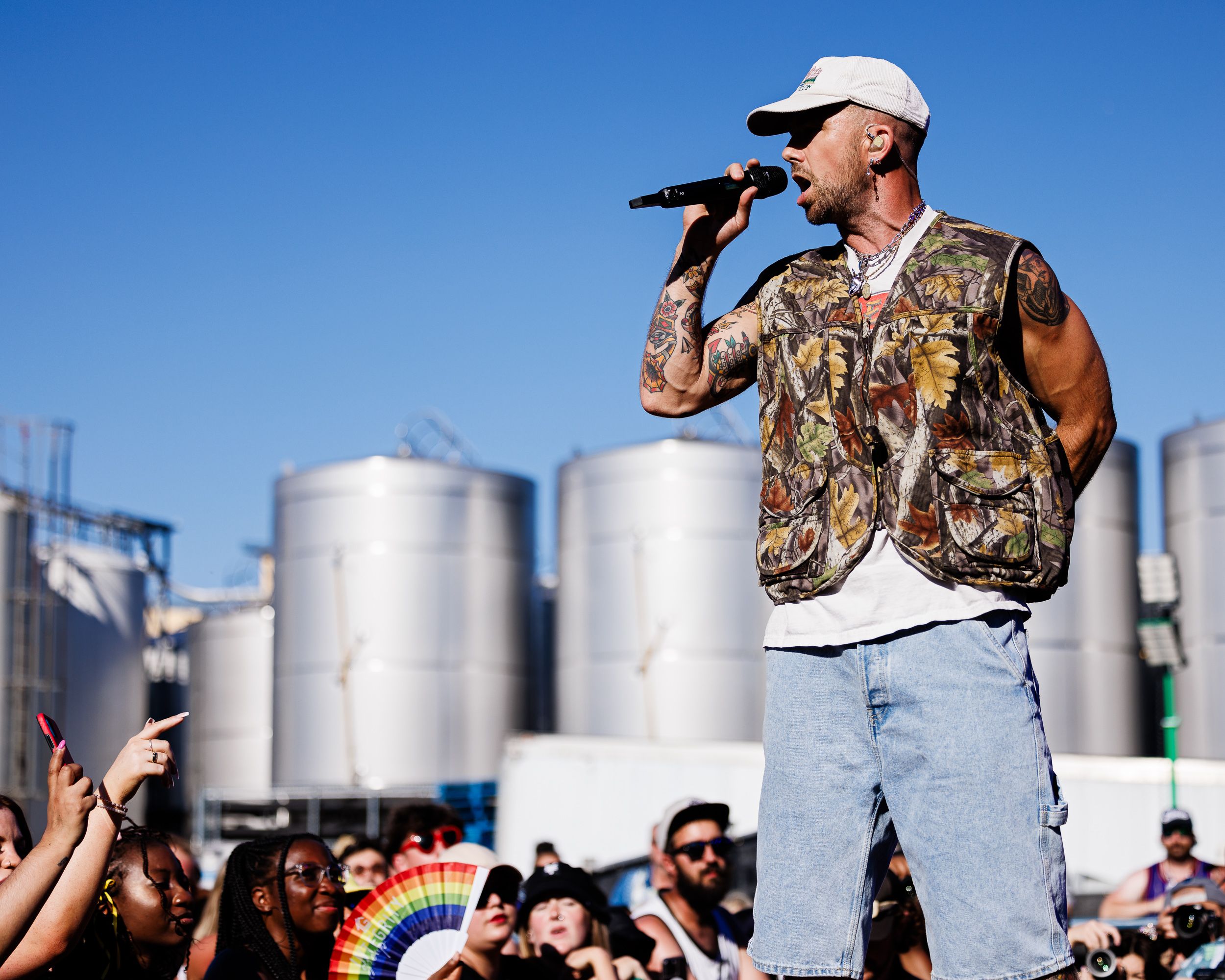 SonReal performing to a festival crowd with grain silos behind the stage