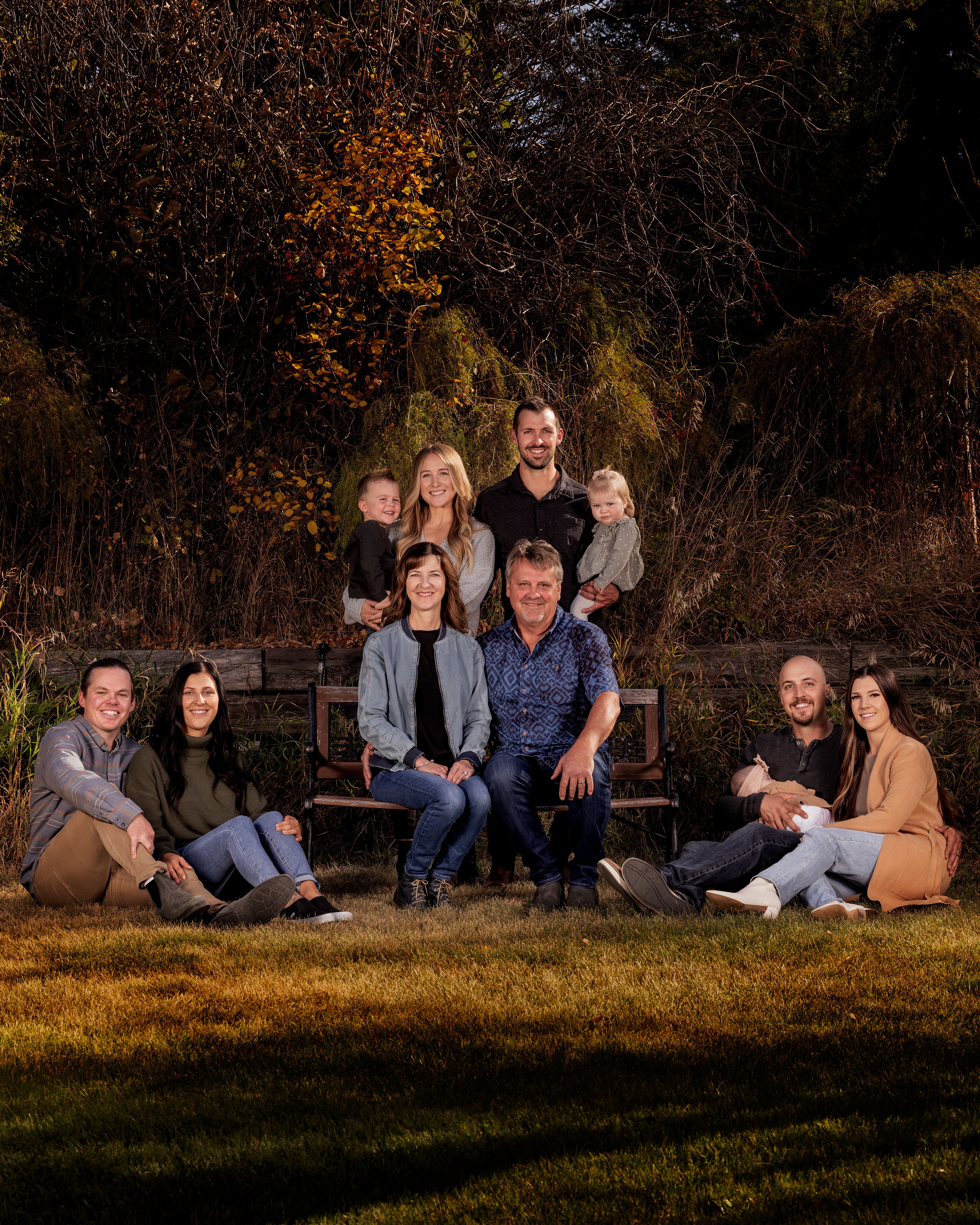 Extended family gathered outdoors in golden autumn light