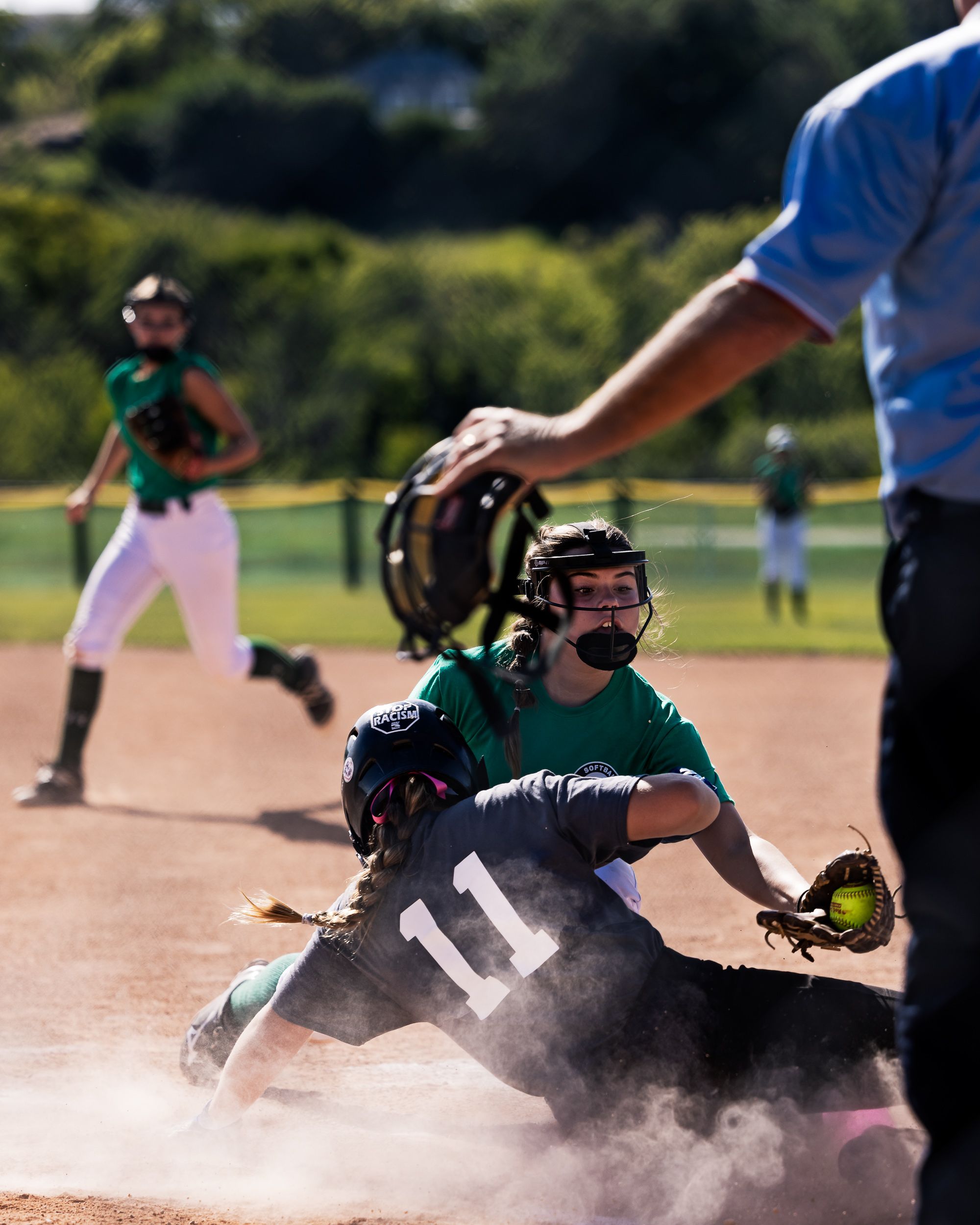 U13 softball player mid-action on the field